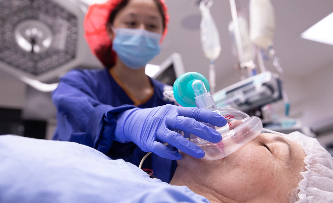 Doctor putting anaesthesia mask on patient