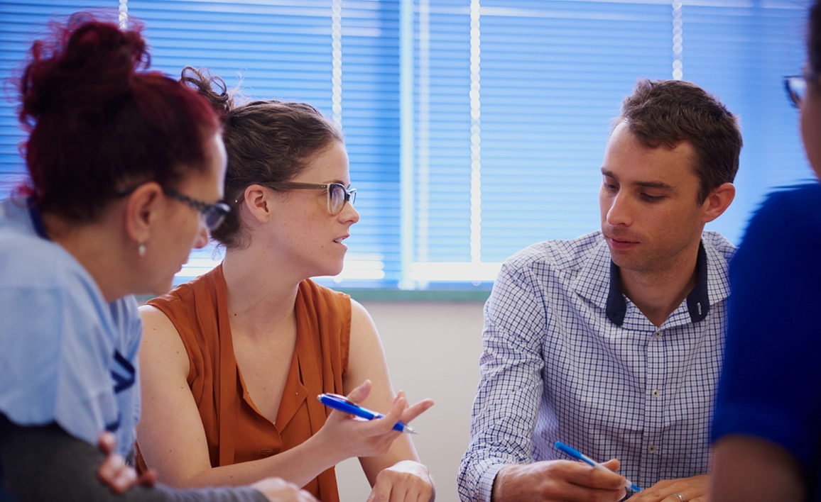 Woman chats with her male and female colleagues in a meeting