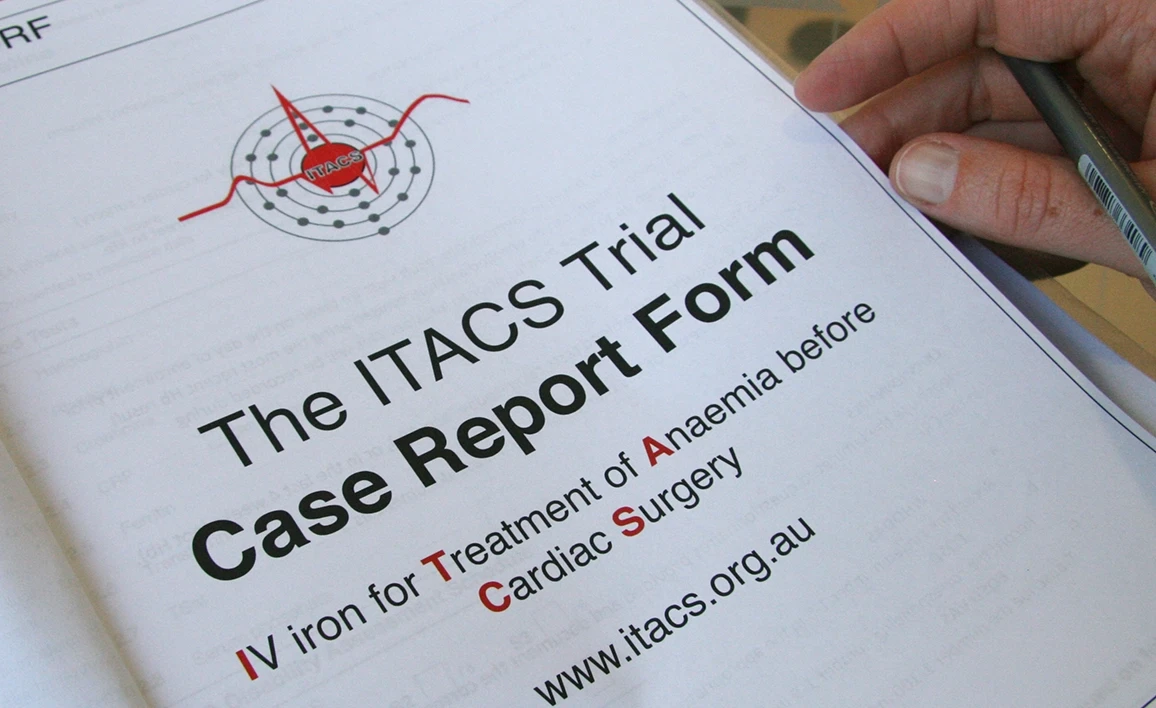 A close-up of a document titled "The ITACS Trial Case Report Form," focusing on IV iron treatment for anemia before cardiac surgery, with a hand holding a pen in the corner.