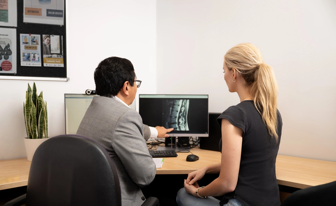 Doctor showing patient X-ray on a screen