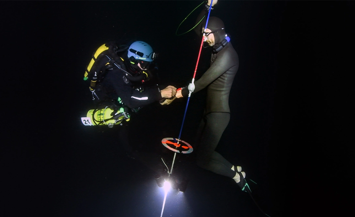 Two divers deep underwater 